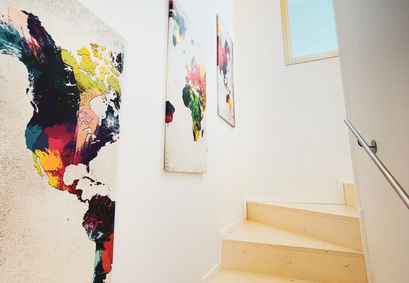 There is a modern staircase that leads up to the second floor. -Artwork can be found on the walls.