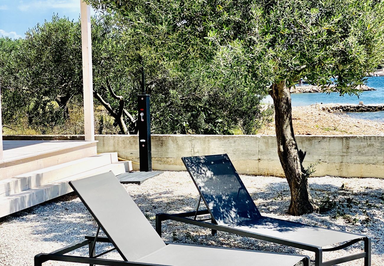 Here on the loungers under the olive tree is a perfect, comfortable place to relax with a view of the sea and right on the beach.