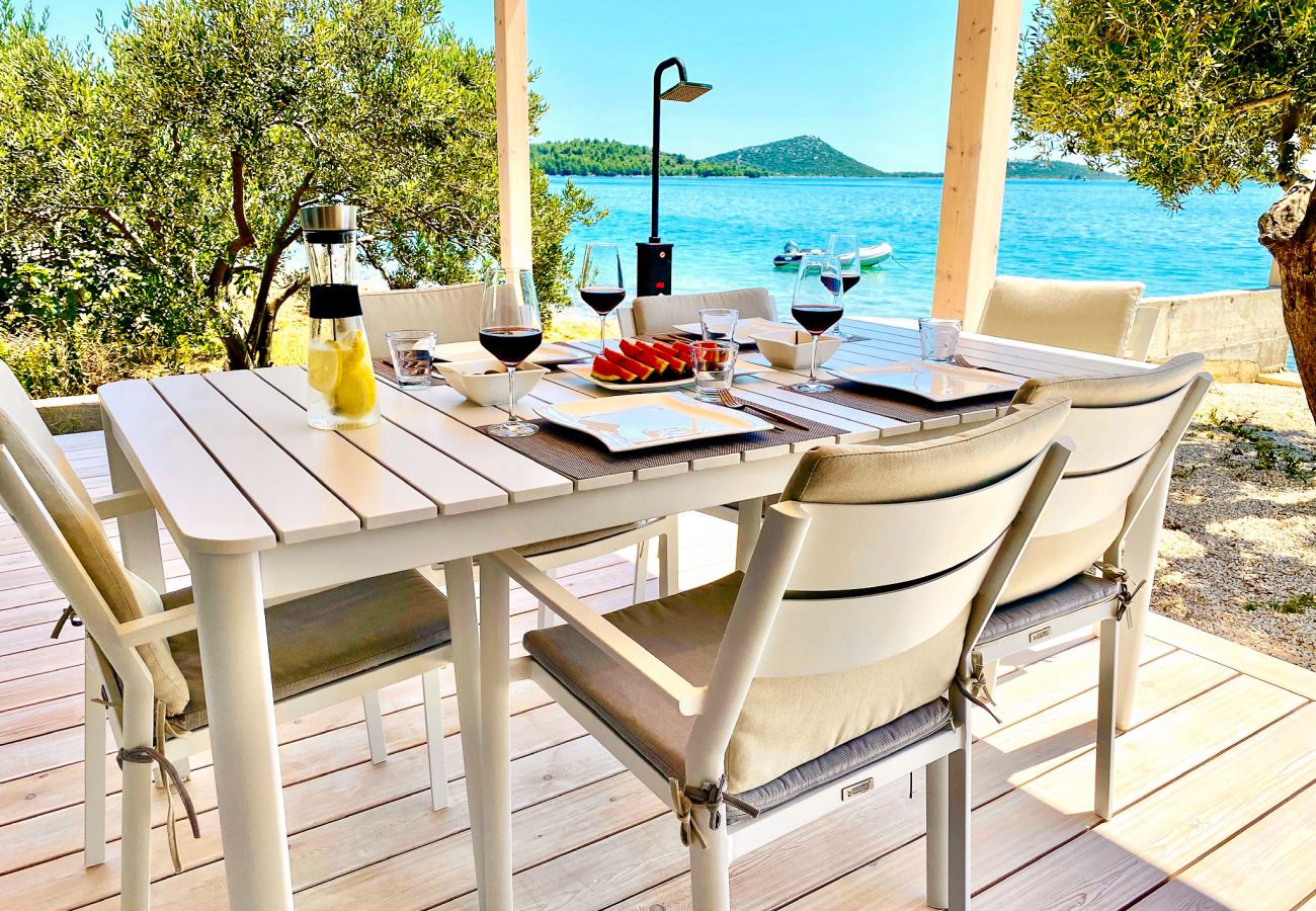 On the terrace there is not only a comfortable dining table but you also have a unique sea view.