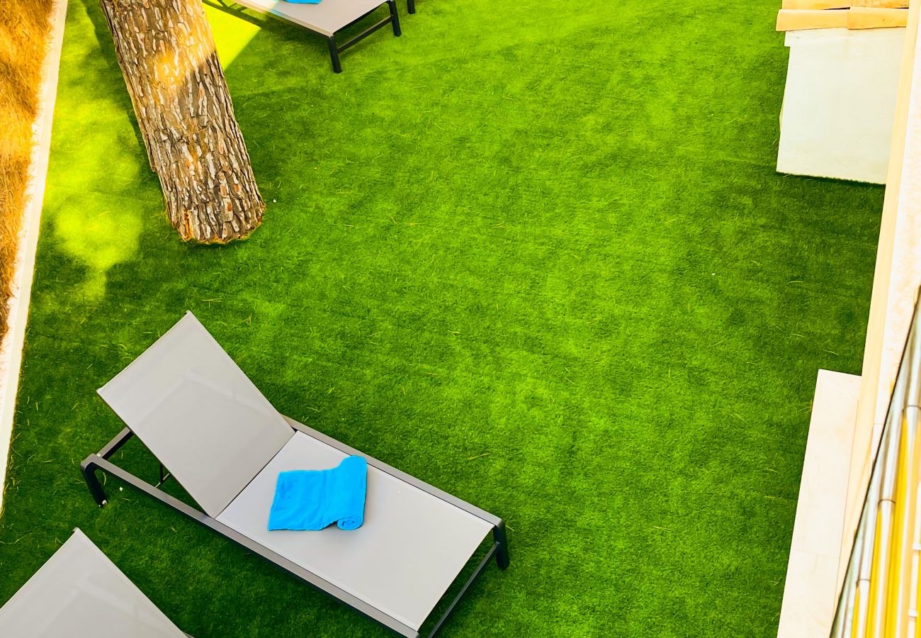 In the middle of the garden you can see comfortable modern loungers perfect for relaxing.