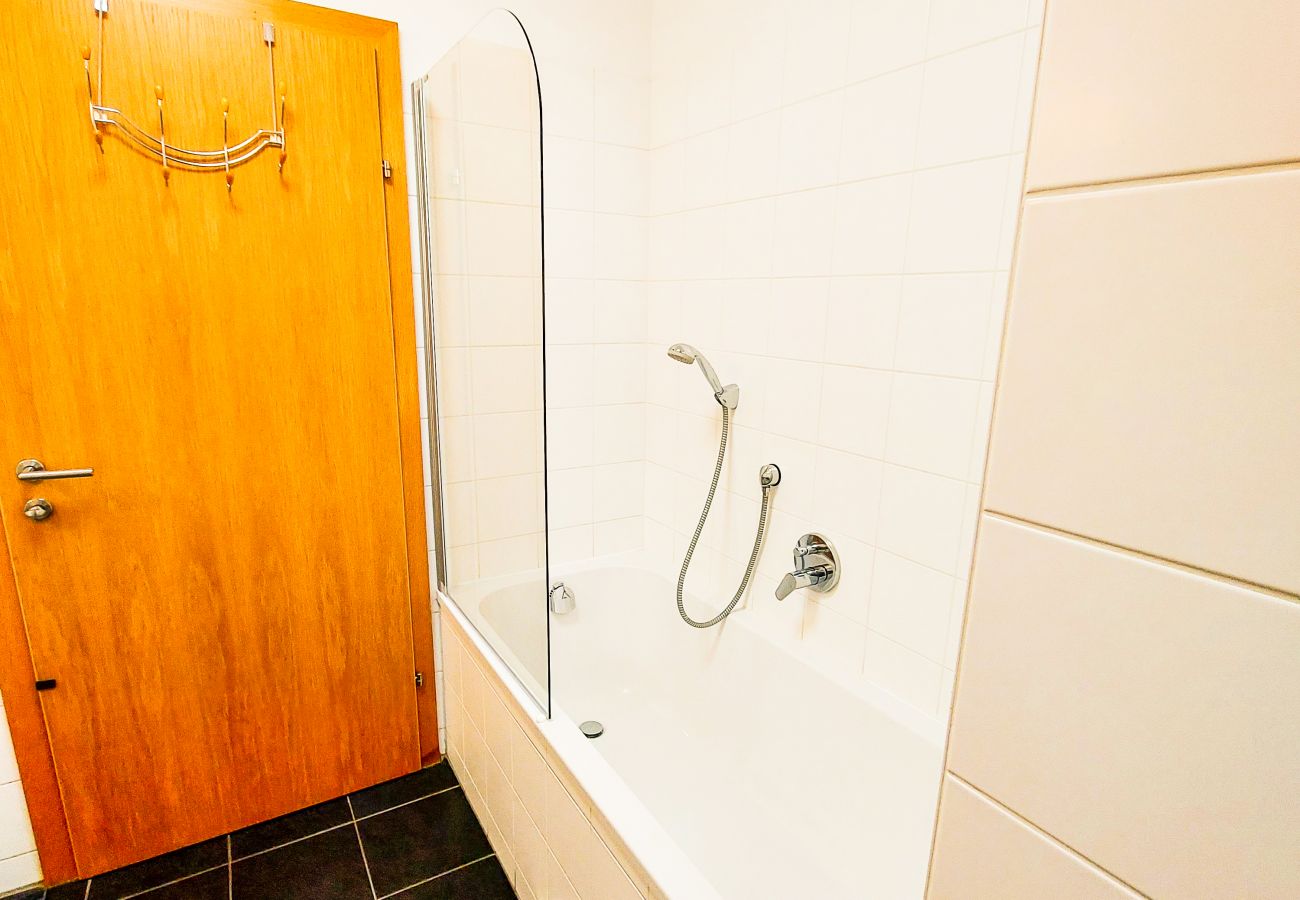 The apartment contains a large simple but modern bathroom.