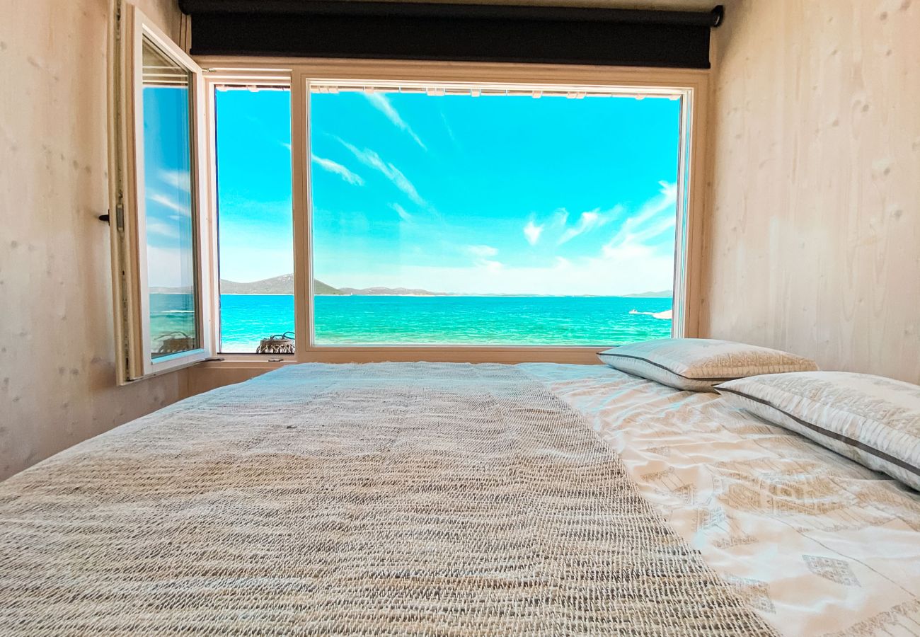 The large double bed in the master bedroom offers a beautiful view of the sea through the large window.