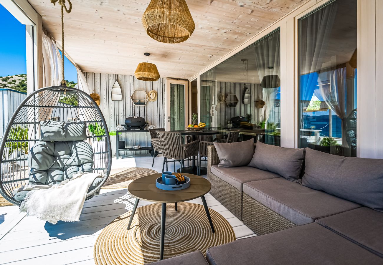 Terrace with sea views, seating area, hanging chair, natural wooden elements and atmospheric lamps