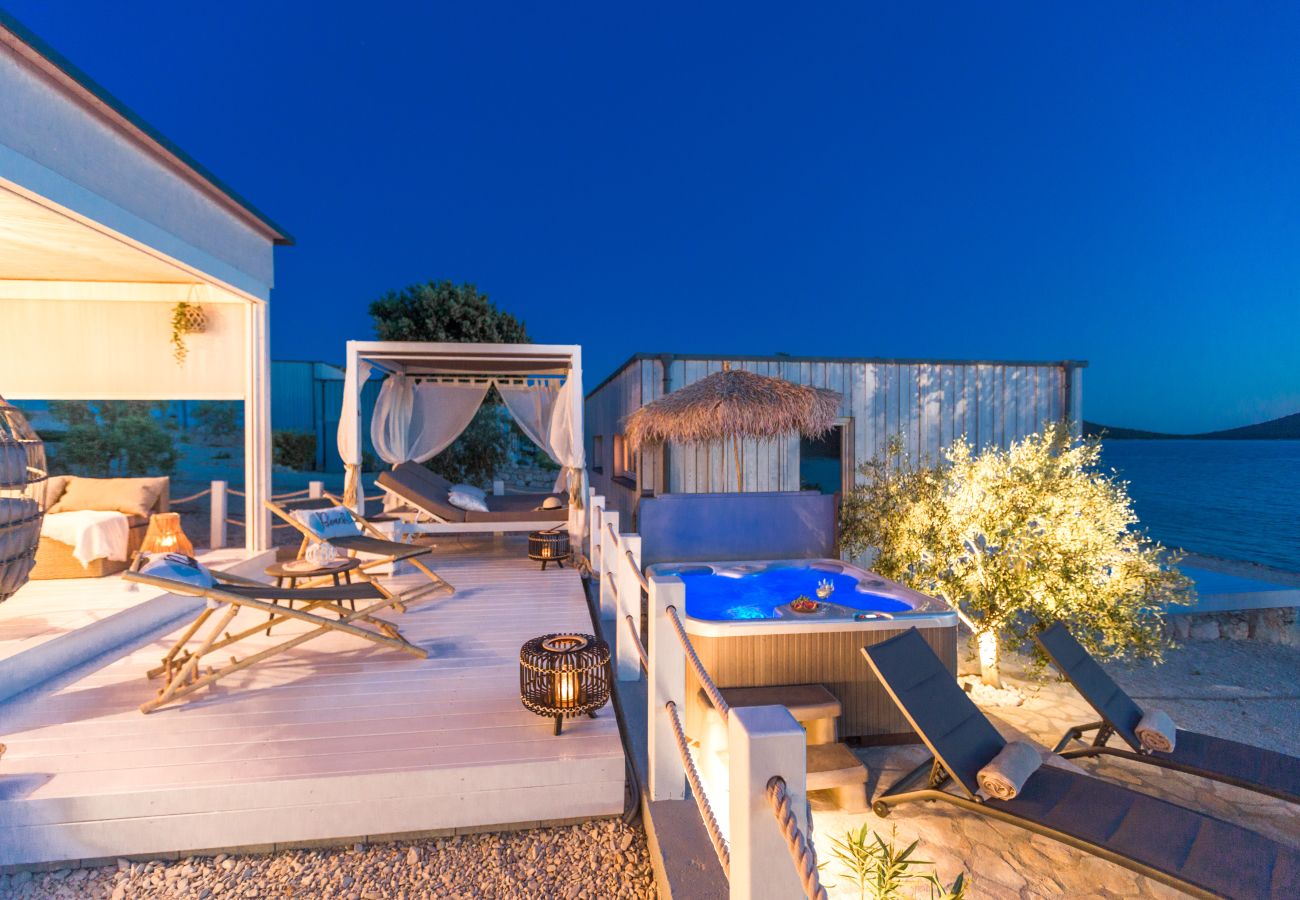 Viele Liegemöglichkeiten sowie ein Whirlpool auf der großen Terrasse vorm Haus und gleichzeitig am Meer.