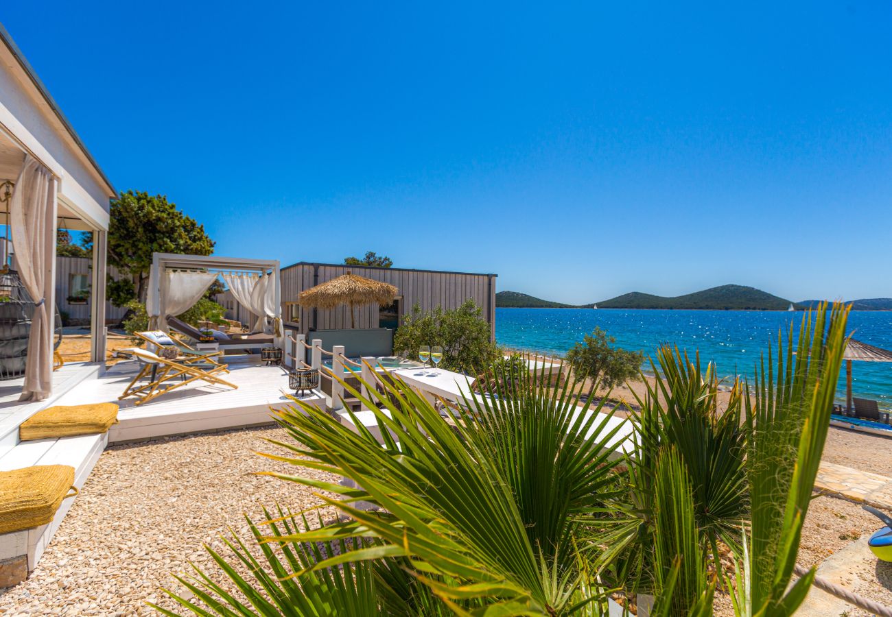 Luxuriöse Terrasse mit Liegestühlen, Loungebereich und Blick auf das Meer und die Inseln