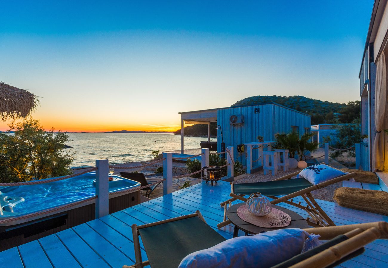 Luxuriöse Terrasse mit Liegen und Whirlpool direkt am Meer